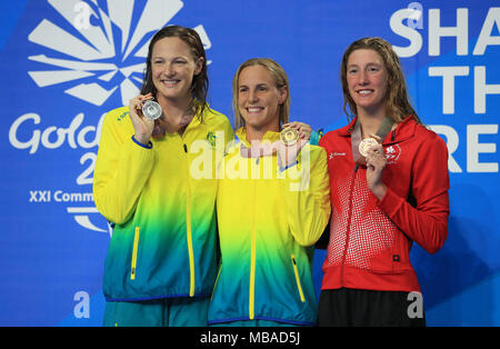 Australia Bronte Campbell celebra vincendo oro con Australia Cate Campbell che ha vinto l'argento in donne 100m Freestyle Finale a fianco del Canada Taylor Ruck che ha vinto il bronzo al Gold Coast centro acquatico durante il giorno cinque del 2018 Giochi del Commonwealth in Gold Coast, Australia. Stampa foto di associazione. Picture Data: lunedì 9 aprile 2018. Vedere PA storia COMMONWEALTH nuoto. Foto di credito dovrebbe leggere: Mike Egerton/filo PA. Restrizioni: solo uso editoriale. Uso non commerciale. Nessun video emulazione. Foto Stock