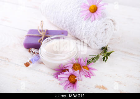 La composizione di trattamento spa su sfondo di legno.sale marino naturale sapone artigianale flover e asciugamano bianco su sfondo di legno . Foto Stock