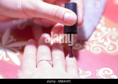 Primo piano delle mani di una donna all'interno di una lampada UV Foto Stock