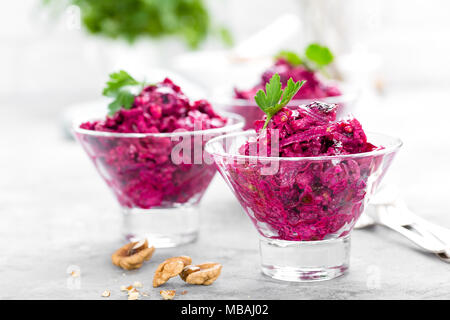 Insalata di barbabietole. Insalata di bollito di barbabietole. La barbabietola rossa con insalata di potare le noci e la panna acida su sfondo bianco Foto Stock