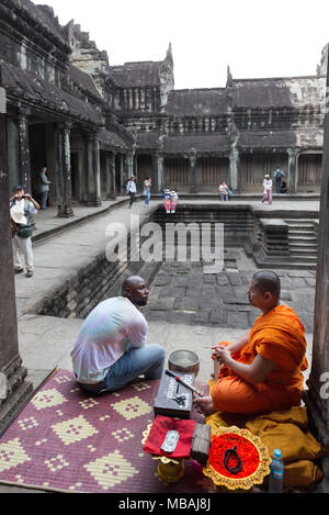 Angkor Wat monk - un monaco a parlare con la gente e dando benedizioni, Angkor Wat, sito patrimonio mondiale dell'UNESCO, Angkor, Cambogia, Asia Foto Stock