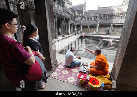 Angkor Wat monk - un monaco a parlare con la gente e dando benedizioni, Angkor Wat, sito patrimonio mondiale dell'UNESCO, Angkor, Cambogia, Asia Foto Stock