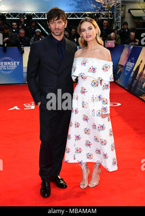 Michiel Huisman (sinistra) e Lily James frequentando il letteraria di Guernsey e la patata Peel Pie Society premiere mondiale tenutosi a Curzon Mayfair, Londra. Foto Stock