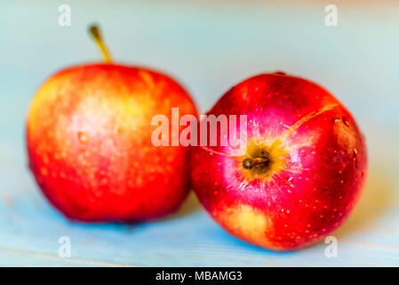 Due interi di mele rosse blu sulla superficie di legno Foto Stock