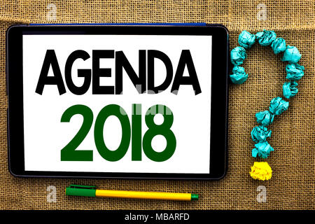 Conceptual la scrittura a mano che mostra l'Agenda 2018. Foto di business Strategia testo cose di pianificazione la pianificazione di obiettivi futuri organizzare scritto il Tablet backg iuta Foto Stock