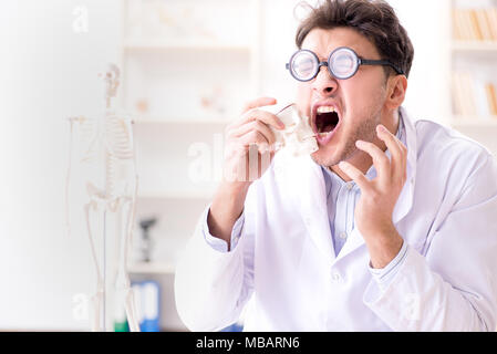 Crazy medico studiando scheletro umano Foto Stock