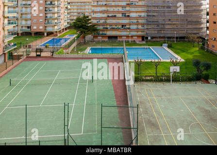 Guardando verso il basso su un campo da tennis, campo da basketball e piscine a Santa Susanna, Spagna. Foto Stock