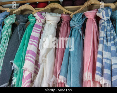 Colorate sciarpe di cotone appesi in un negozio di marocchini in un souk di Marrakech. Le sciarpe sono state fatte a mano dal proprietario del negozio. Foto Stock