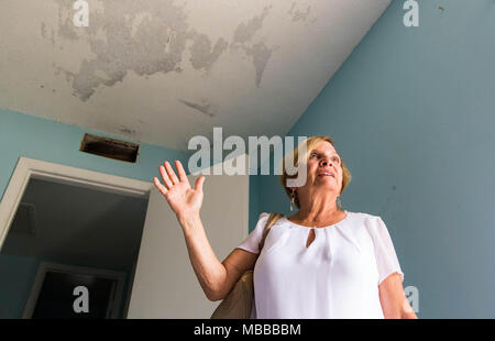 Aprile 10, 2018 - Palm Beach Gardens, Florida, Stati Uniti - Martha Zuniga, proprietario di un legno di sandalo Estates in condominio che era stata danneggiata da un uragano Irma, è ancora in attesa di fare le riparazioni fino a quando la perdita del tetto è fissato in Palm Beach Gardens, Florida il 9 aprile 2018. Sette mesi dopo l uragano Irma, meno della metà dei 39.000 rivendicazioni in Palm Beach County sono stati chiusi con il pagamento. Florida della seconda più grande assicuratore cittadini ha riaperto oltre 24.000 rivendicazioni, o circa 37 percento, statewide per esaminare se i proprietari meritano più di pagamento. (Credito Immagine: © Allen Eyestone/Palm Beach post tramite filo di ZUMA Foto Stock