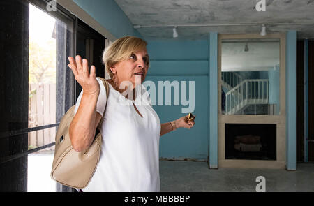 Aprile 10, 2018 - Palm Beach Gardens, Florida, Stati Uniti - Martha Zuniga, proprietario di un legno di sandalo Estates in condominio che era stata danneggiata da un uragano Irma, è ancora in attesa di fare le riparazioni fino a quando la perdita del tetto è fissato in Palm Beach Gardens, Florida il 9 aprile 2018. Sette mesi dopo l uragano Irma, meno della metà dei 39.000 rivendicazioni in Palm Beach County sono stati chiusi con il pagamento. Florida della seconda più grande assicuratore cittadini ha riaperto oltre 24.000 rivendicazioni, o circa 37 percento, statewide per esaminare se i proprietari meritano più di pagamento. (Credito Immagine: © Allen Eyestone/Palm Beach post tramite filo di ZUMA Foto Stock