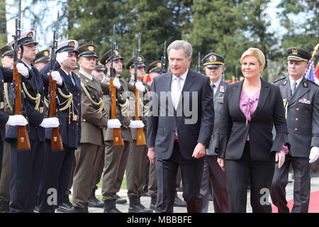 (180410) -- ZAGREB, 10 aprile 2018 (Xinhua) -- la Visita Presidente finlandese Sauli Niinisto (L) anteriore e il presidente croato Kolinda Grabar-Kitarovic (R) anteriore ispezionare la guardia d'onore durante una cerimonia di benvenuto di fronte al Palazzo Presidenziale a Zagabria, la capitale della Croazia, il 10 aprile 2018. Sauli Niinisto è su una visita di stato in Croazia da martedì a giovedì. (Xinhua/Patrik Macek) (zjl) Foto Stock