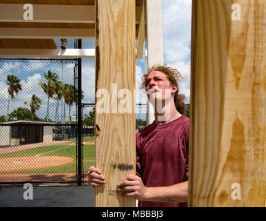 Aprile 10, 2018 - Palm Beach Gardens, Florida, Stati Uniti - Abraham Carswell, West Palm Beach, attende a mano fino a bordo durante la costruzione di una struttura di ombra al Gardens Park campi da baseball. Carswell lavora per Gold Coast e la costruzione di nuove strutture permanenti sarà ombra gradinate e di fornire protezione in caso di condizioni meteo avverse al parco su ustioni road. La costruzione, compresi i miglioramenti per la concessione si erge, è stanziato a $375.000. (Credito Immagine: © Allen Eyestone/Palm Beach post via ZUMA filo) Foto Stock