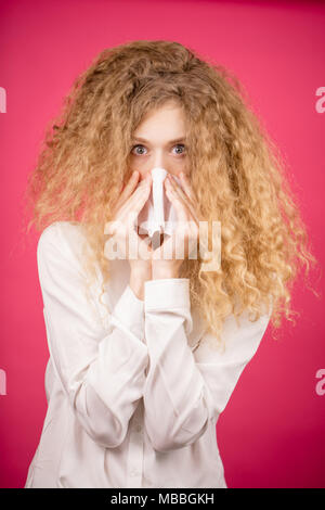 Scioccato giovane donna bionda con capelli ribelli dopo andare al salone di parrucchiere Foto Stock