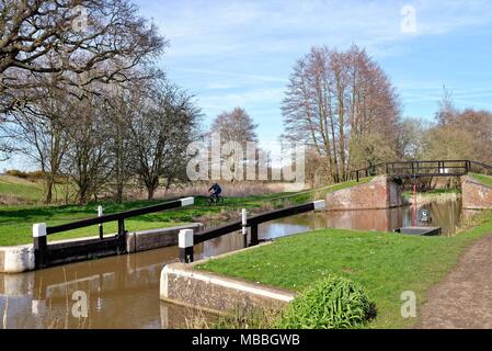 Maschio anziano ciclista dal fiume Wey navigazione a Walsham blocco su una soleggiata giornata di primavera,Ripley Surrey in Inghilterra REGNO UNITO Foto Stock