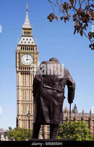 Westminster, Londra. Il Winston Churchill statua in piazza del Parlamento, visto da dietro con il Palazzo di Westminster e il Big Ben in background Foto Stock