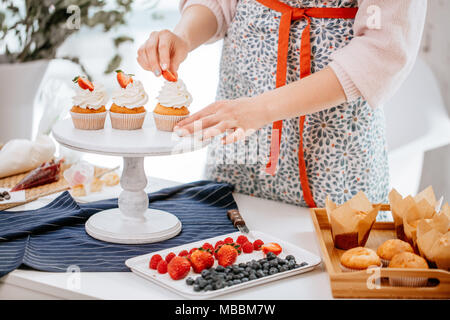 Processo di come decorare le tortine con frutti di bosco Foto Stock