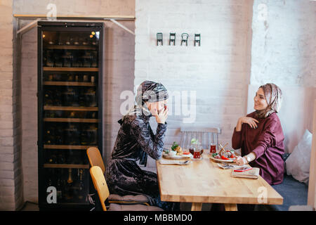 Due donne musulmane in cafe, riunione amici Foto Stock