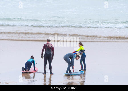 Un gruppo di surfers preparando per navigare in mare a Fistral in Newquay Cornwall. Foto Stock