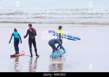 Un gruppo di surfers preparando per navigare a Fistral in Newquay Cornwall. Foto Stock
