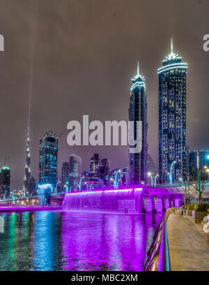 Una vista di edifici alti in Business Bay area illuminata di notte a Dubai, UAE, Medio Oriente. Foto Stock