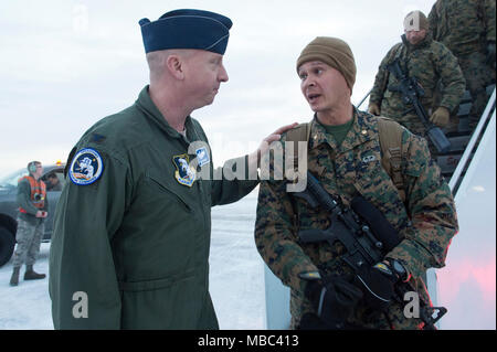 Air Force Col. Mark Schmidt, direttore delle operazioni di comando in Alaska, saluta la visita U.S. Marines con lo scopo speciale Marine-Air-Massa Force-Arctic attività di bordo 18 come essi arrivano a base comune Elmendorf-Richardson, Alaska, Feb 13, 2018. I marines sono a JBER a sostegno di Arctic Edge 2018, una biennale su grande scala, joint-esercizio che prepara e prove il militare degli Stati Uniti è la sua capacità di operare tatticamente nel freddo estremo-Condizioni meteorologiche rilevate in ambienti artici. Sotto l'autorità del North American Aerospace Defense e U.S. Comando Nord, più di 1500 particip Foto Stock