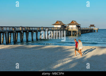 Giovane camminando lungo la spiaggia la mattina presto a Napoli molo lungo la costa del Golfo della Florida, Naples, Florida, Stati Uniti d'America Foto Stock