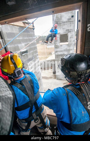 Un vigile del fuoco dal Mississippi Task force ricerca urbana e la squadra di salvataggio sfugge simulato un edificio crollato durante l'esercizio PATRIOT Sud 18, a Camp Shelby, Miss. su 14 Febbraio, 2018. Patriota del Sud, una joint-agenzia operazioni domestiche esercitazione, si concentra sulla preparazione ai disastri naturali non solo per la Guardia Nazionale di unità di tutta la nazione, ma anche civili di prima emergenza. (Ohio Air National Guard Foto Stock