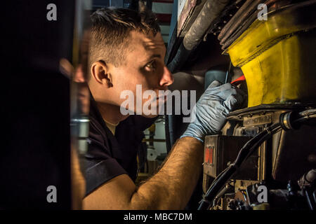 Il personale Sgt. Brice Patterson ispeziona l'unità di alimentazione ausiliaria come aviatori lavoro sul C-130H Hercules durante un isocrono ispezione del 14 febbraio 2018, presso il 179th Airlift Wing, Mansfield, Ohio. Il 179th gruppo Manutenzione è di eseguire una ispezione completa del recentemente acquisita da aeromobili Yokota Air Base, Giappone, un aeromobile storicamente noto in tutti gli Stati Uniti Air Force come 'Damien' per i suoi unici numeri di coda di 666. (U.S. Air National Guard Foto Stock