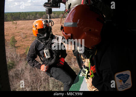 Membri della Carolina del Sud di elicottero di salvataggio acquatico Team e soldati con la Carolina del Sud National Guard per simulare un elicottero su un UH-60 Black Hawk durante il patriota sud 18 esercizio a Camp Shelby, Miss., Feb 15, 2018. PATRIOT Sud 2018 prove di abilità combinate della Guardia nazionale, insieme con le agenzie statali e locali, per rispondere durante calamità naturali mediante simulazione di scenari di emergenza. (U.S. Air National Guard Foto Stock