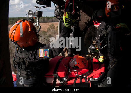 Membri della Carolina del Sud di elicottero di salvataggio acquatico Team e soldati con la Carolina del Sud National Guard per simulare un elicottero su un UH-60 Black Hawk durante il patriota sud 18 esercizio a Camp Shelby, Miss., Feb 15, 2018. PATRIOT Sud 2018 prove di abilità combinate della Guardia nazionale, insieme con le agenzie statali e locali, per rispondere durante calamità naturali mediante simulazione di scenari di emergenza. (U.S. Air National Guard Foto Stock