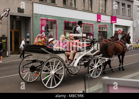 Una carrozza trainata da cavalli porta i turisti in giro per le strade di Vienna, Austria. Foto Stock