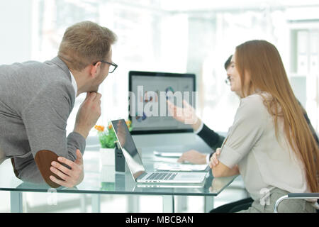 Il team di business funziona con le statistiche del progetto i dati utilizzando un computer portatile Foto Stock