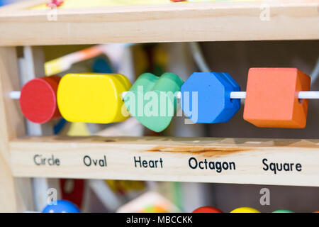 Giocattoli di legno per apprendere e giocare con forme e colori (messa a fuoco selettiva) Foto Stock