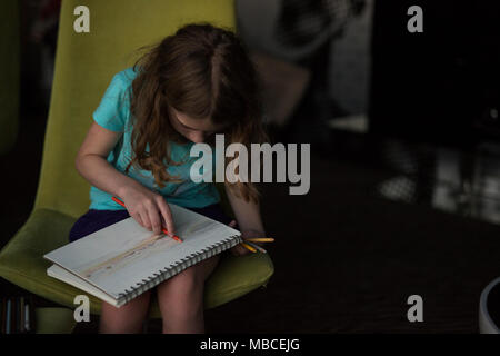 Un undici-anno-vecchia ragazza tween disegno il tramonto in una camera di hotel a Brno, in Repubblica Ceca. Foto Stock