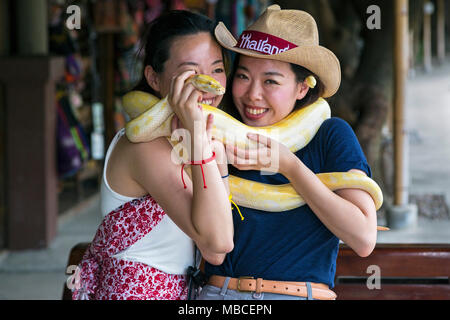 Turisti asiatici con snake, Damnoen Saduak, Ratchaburi, Thailandia Foto Stock