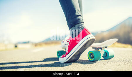 Close-up della ragazza in piedi e penny scheda. Foto Stock