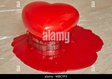 Processo di colata di smalto rosso a forma di cuore forma mousse, cibo fatto in casa Foto Stock