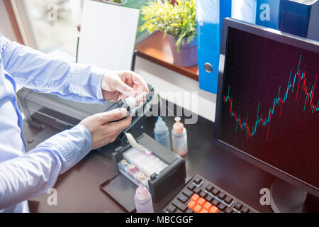 L'uomo apre il contenitore con l'inchiostro nero per la stampante Foto Stock