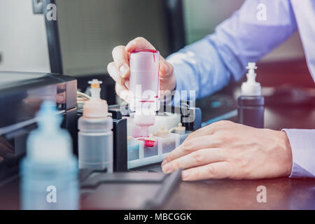 L'uomo compie il contenitore di inchiostro nella sua stampante Foto Stock