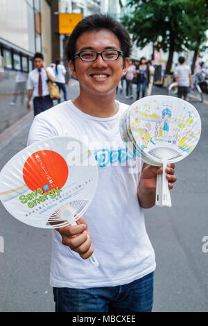 Tokyo Japan,Shinjuku,Street scene,kanji,personaggi,simboli,Inglese Giapponese,Asiatico Orientale,uomo uomini maschio adulti,offrendo gratuitamente tifosi,vendere,announ Foto Stock