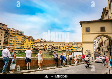 Firenze, Italia, Giugno 2015: turisti camminare e scattare foto lungo il famoso Lungarno vicino a Ponte Vecchio a Firenze su un soleggiato inizio giornata estiva Foto Stock