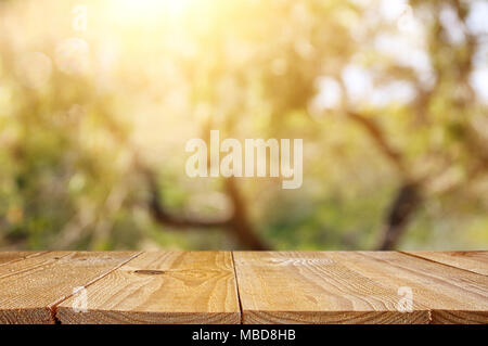 Svuotare tavolo rustico nella parte anteriore della molla verde astratto sfondo bokeh. display del prodotto e concetto di picnic Foto Stock