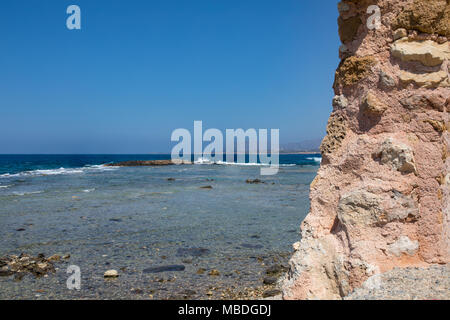 Colorate le onde del mare presso la costa rocciosa nella parte orientale dell'isola. Offuscata dal moto dell'acqua. Giornata di sole a Creta. Foto Stock