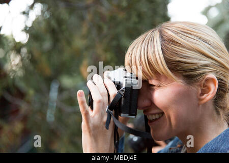 Donna sorridente con la fotocamera Foto Stock