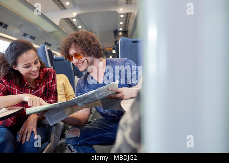 Coppia giovane guardando la mappa sul treno passeggeri Foto Stock