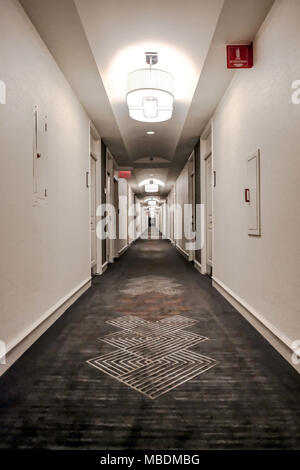 Vista astratta di un hotel vuoto lobby e nel corridoio che mostra il tunnel effetto di visione a distanza. Fire escape segni e illuminazione sono visibili. Foto Stock