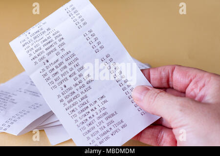 Femmina lato tenendo un supermercato a fare la spesa fino al ricevimento, England, Regno Unito Foto Stock