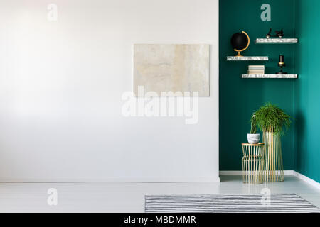 Luminoso dipinto sul muro bianco e piante contro la parete verde in salotto interno con spazio di copia Foto Stock