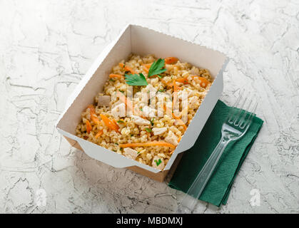 Cibo sano e consegna. Pilov da bulgur con carne di pollo. Prendere via del rapporto giornaliero dei pasti in scatole di carta. Vista superiore Foto Stock