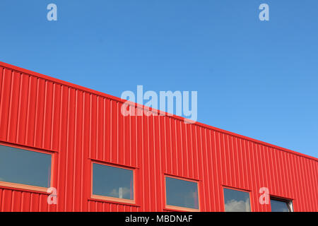 Minimalista del paesaggio urbano con un edificio rosso e un cielo blu chiaro Foto Stock